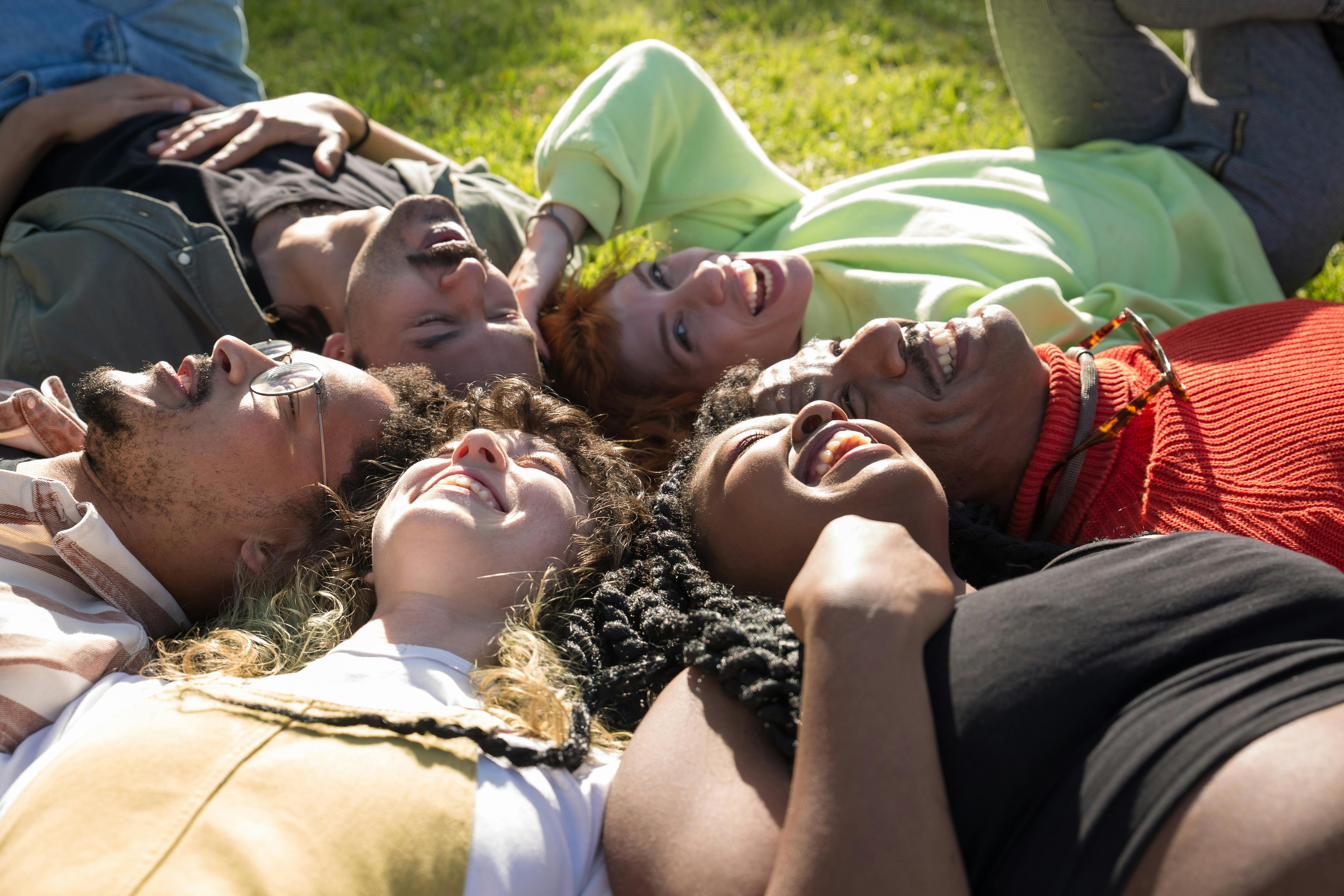 Group of people lying on the grass with a relaxed posture The Peace Behind Our Mission