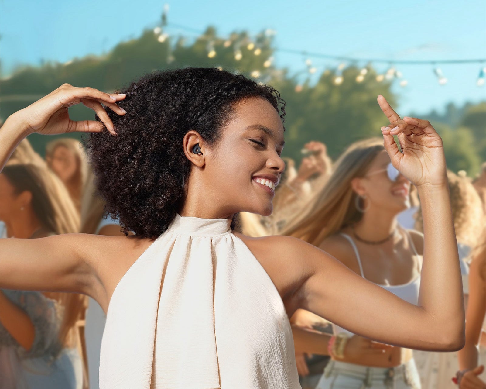Woman dancing outdoors in a music festival with Welove noise canceling earplugs 