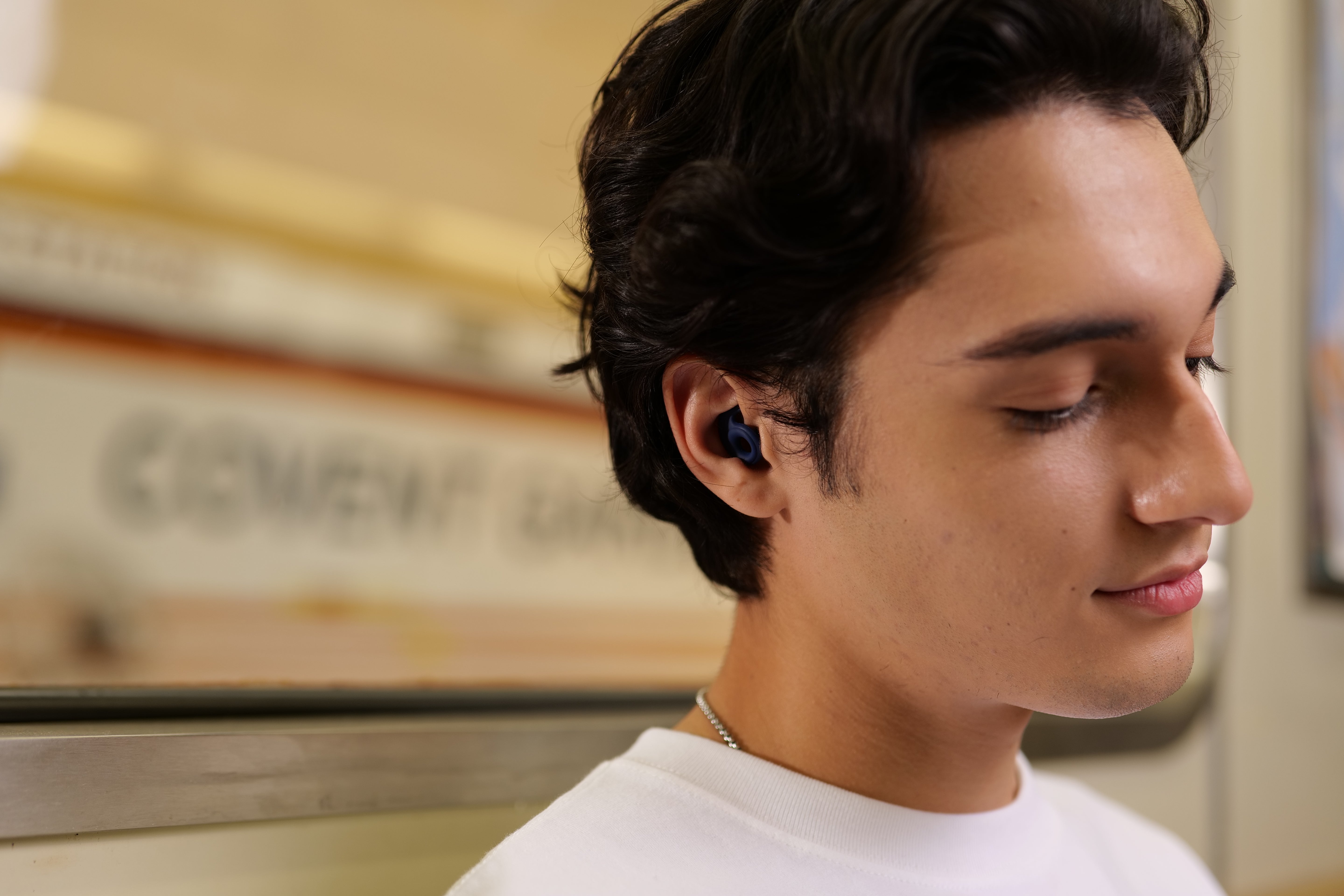Person wearing Travel-Friendly Earplug during his commute, earplugs are Lightweight, Compact & Ready to Go — Block travel noise and enjoy peace on flights, commutes, and road trips.